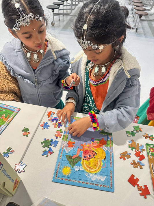 Two sisters enjoying playing with their Hanuman puzzle during Hindu festival Navratri