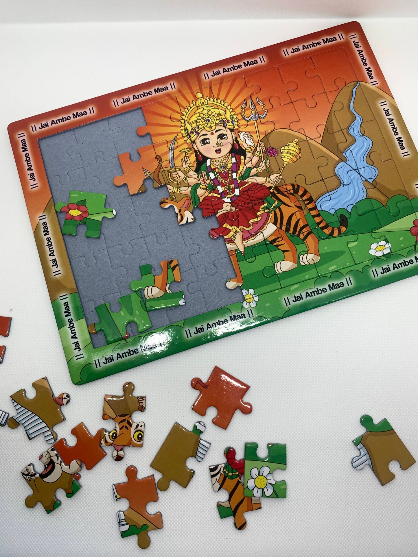 Children's puzzle of Hindu Goddess Ambe Ma and scattered pieces on a white background