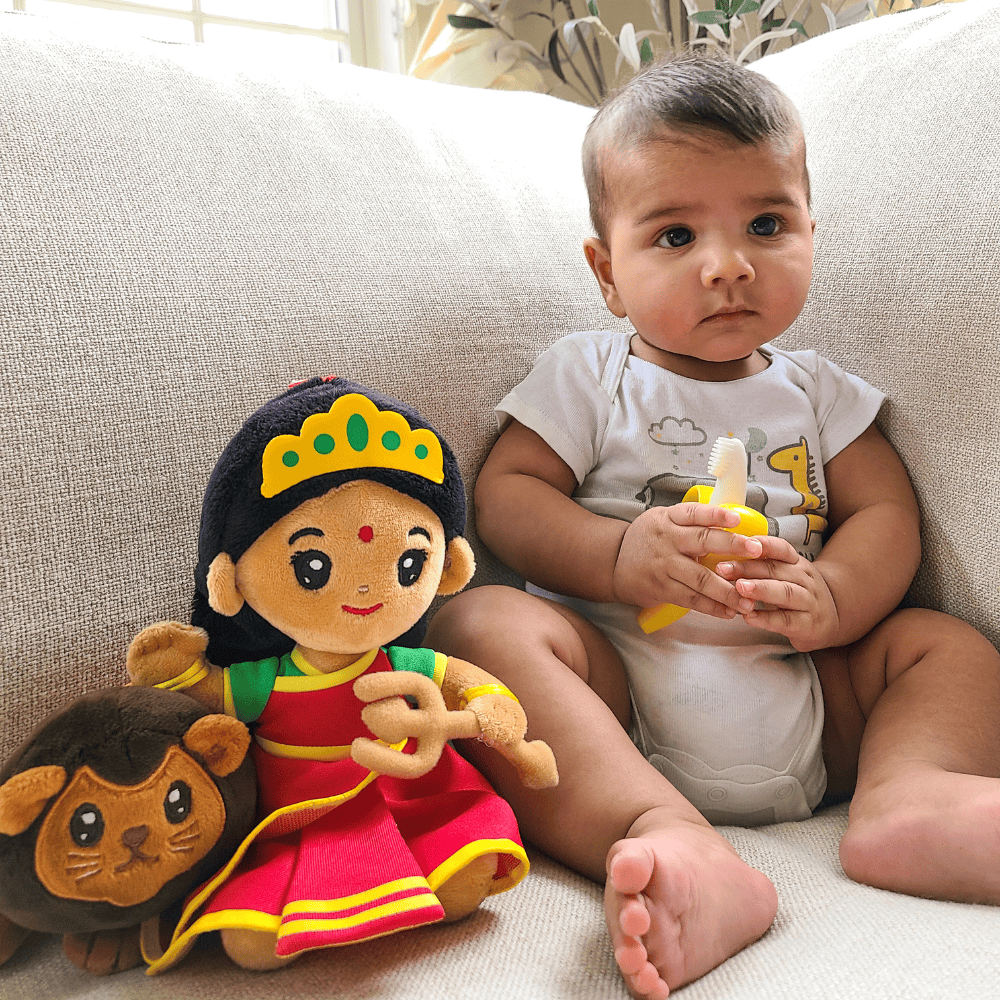 Baby sitting on a couch with medium Durga devi 