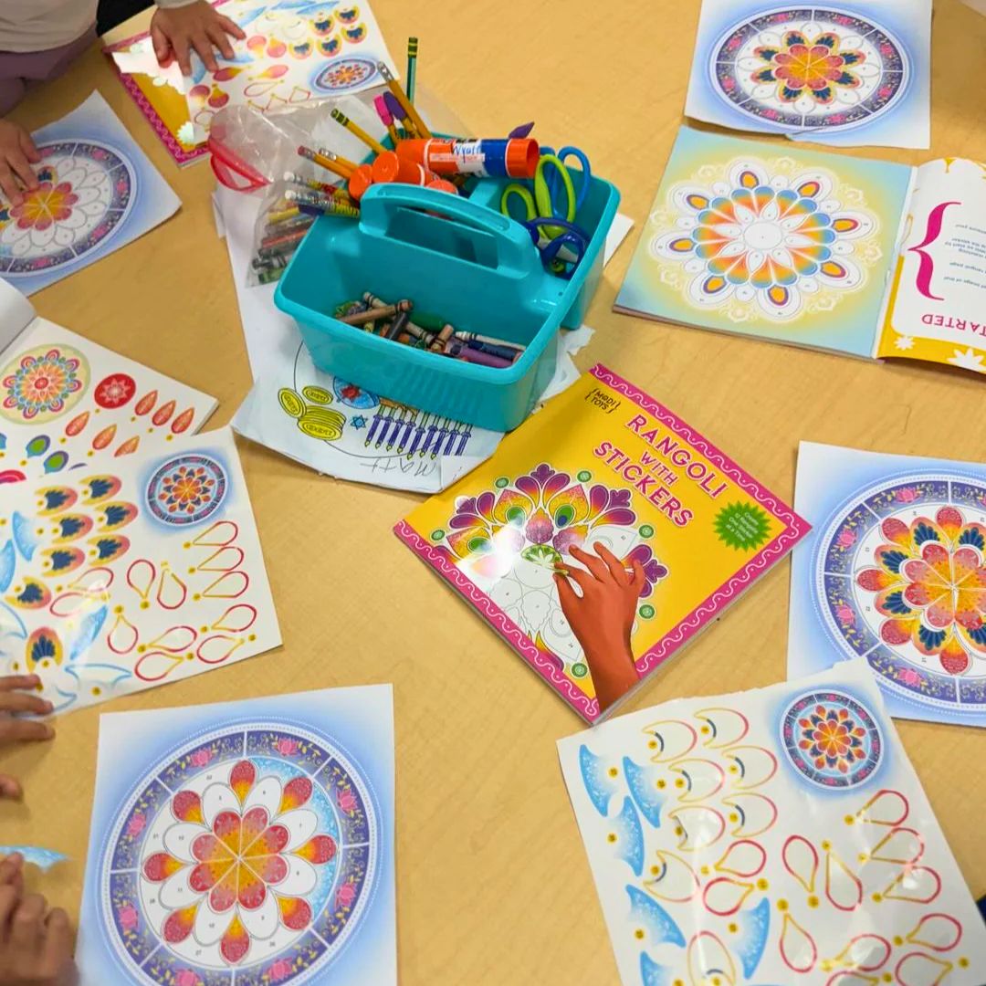Children's art supplies and rangoli books on a table