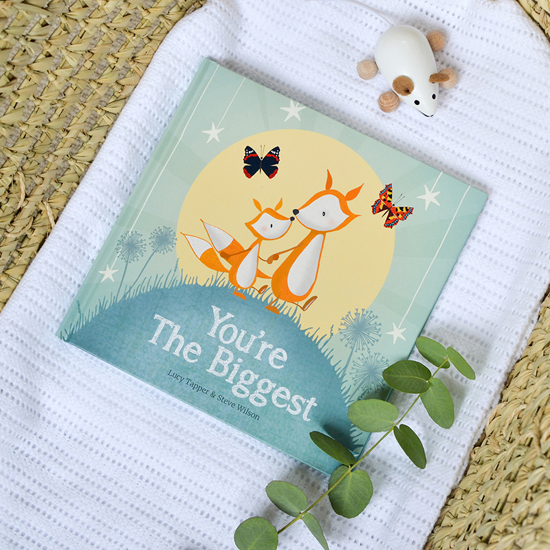Children's book titled 'You're The Biggest' with fox illustration on a textured surface.