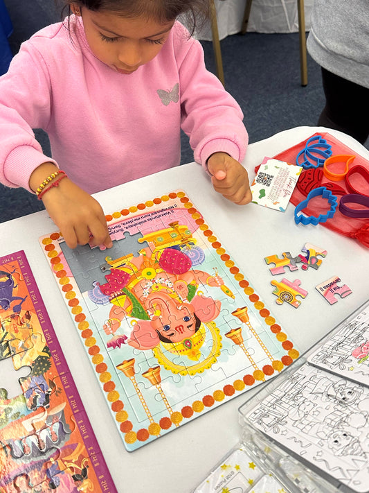 Child playing with Ganesha jigsaw puzzle with some pieces on the side