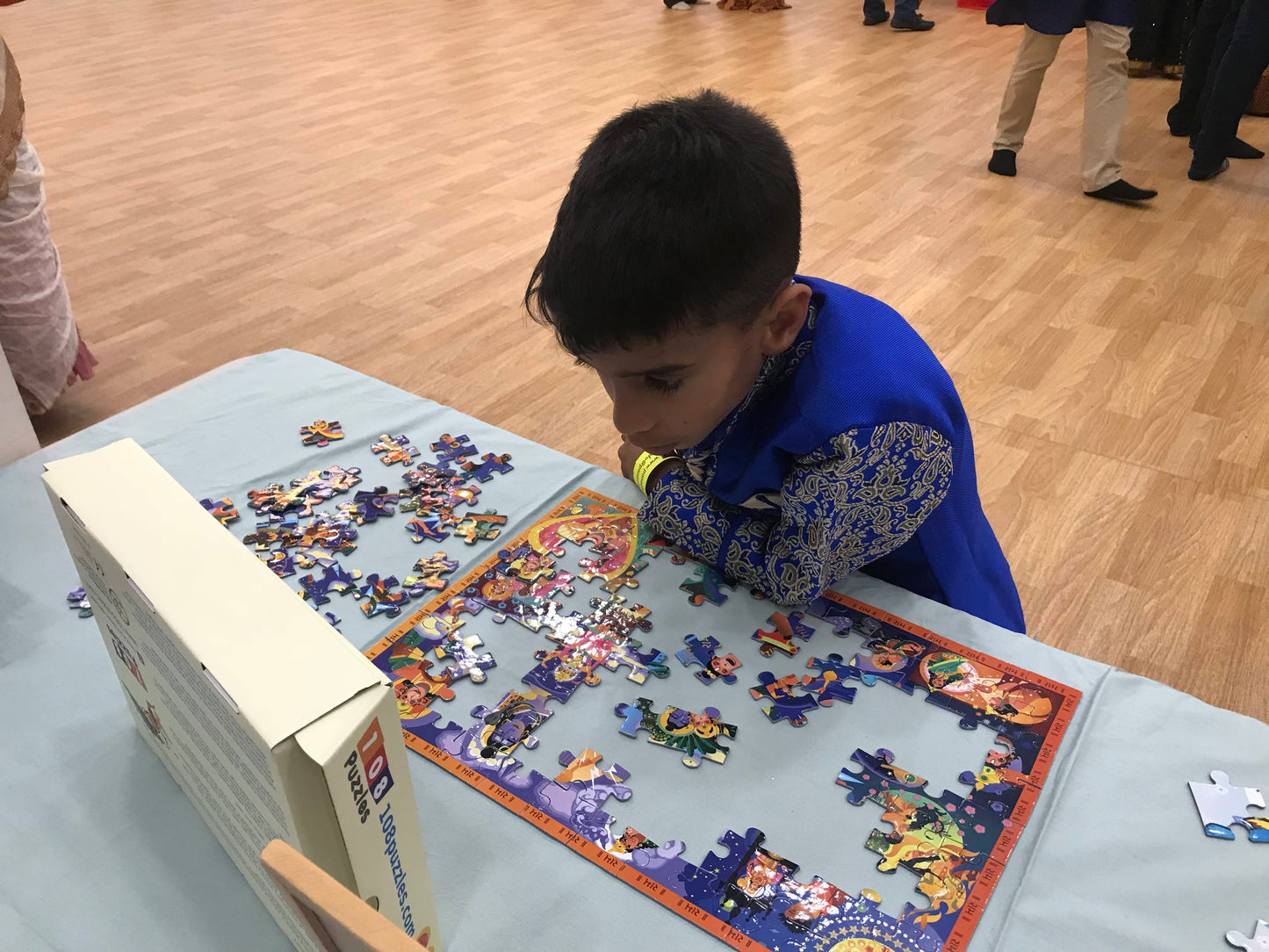 Child playing with a Hanuman puzzle at a table at a Diwali event.