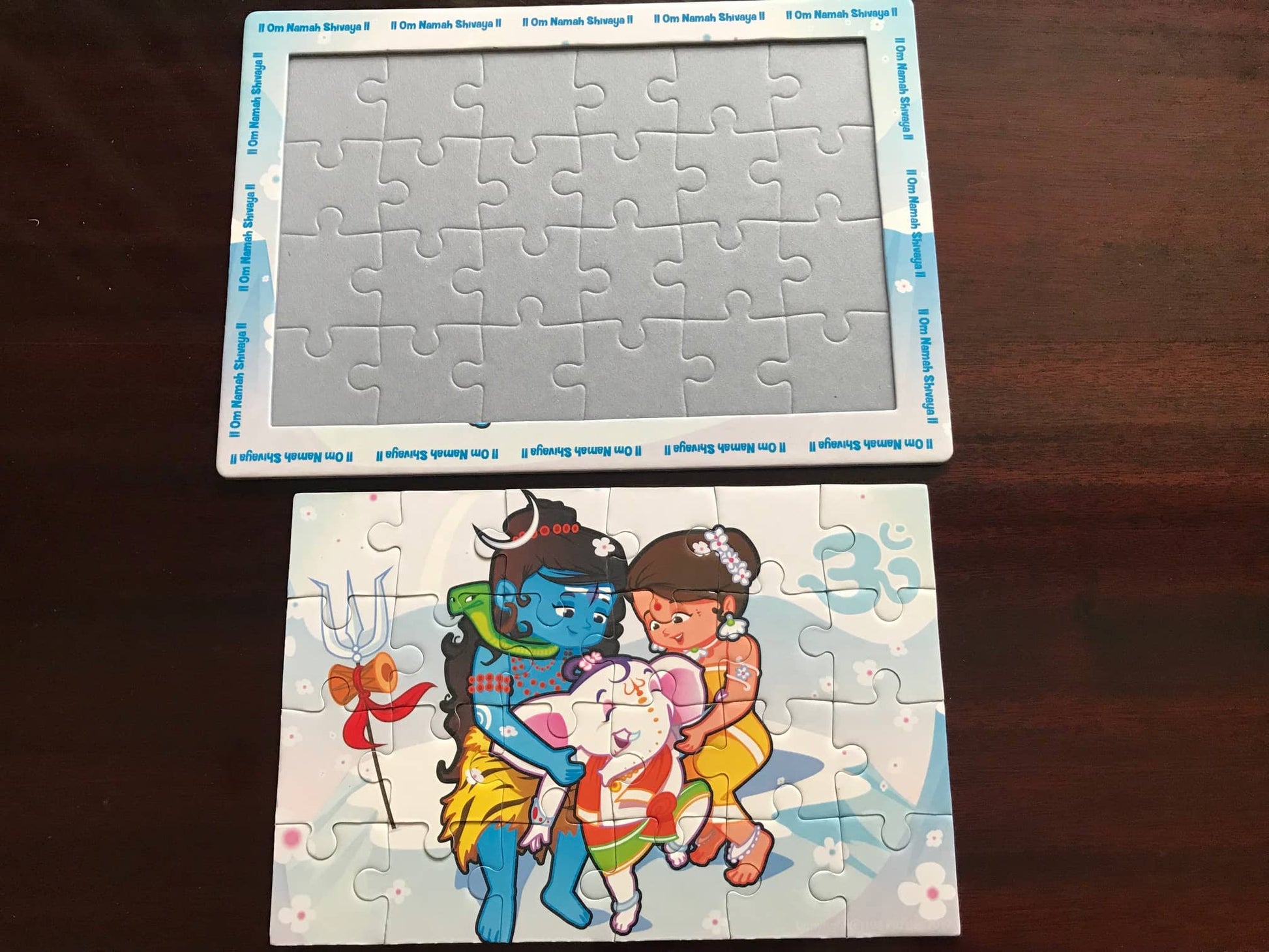 Shiva Ganesha puzzle completed outside of the tray on wooden table