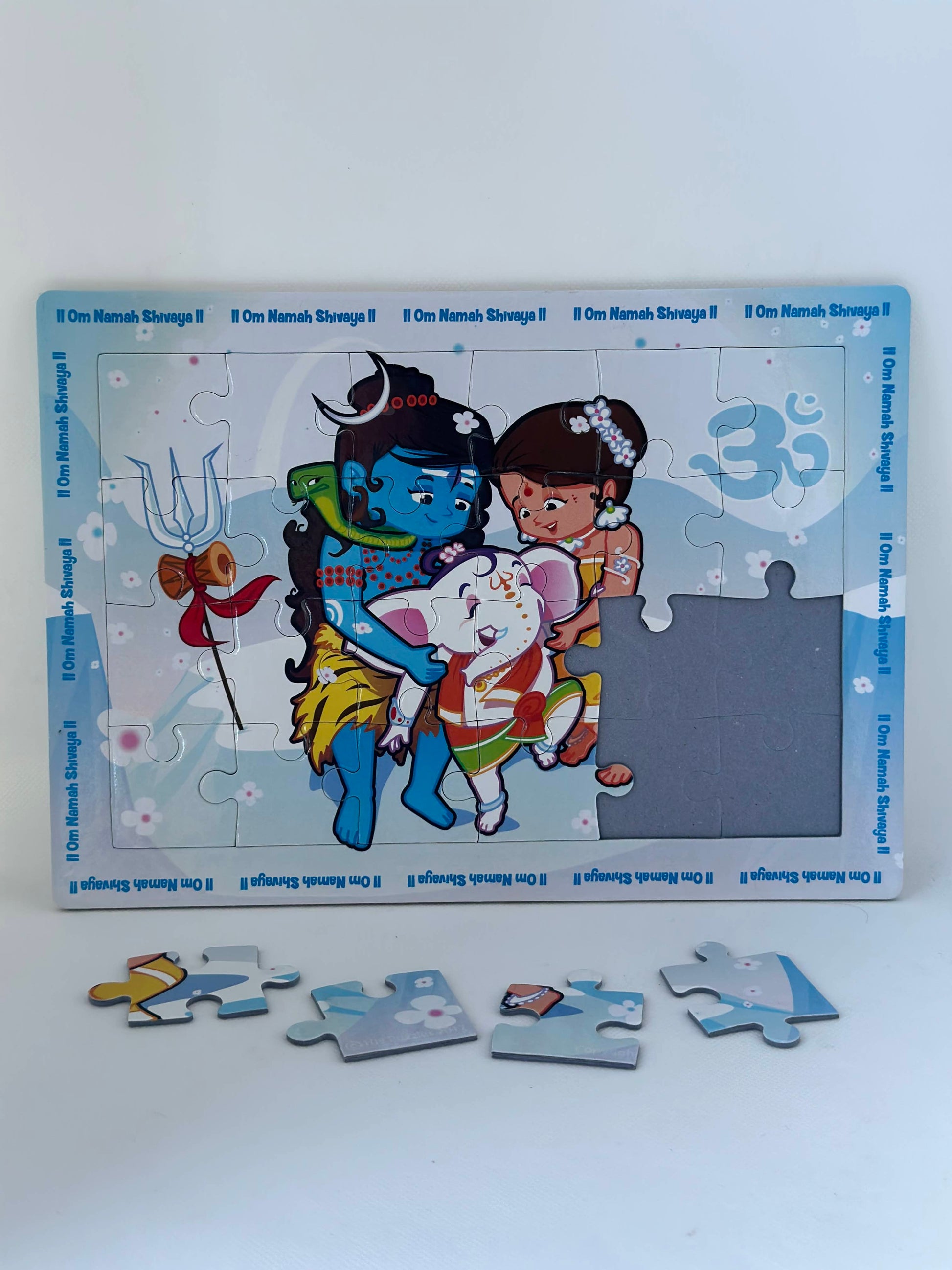 Illustration of Shiva Ganesha Parvati in puzzle form specifically designed for kids with a few pieces out of the tray