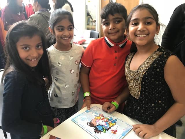 Four children with huge smiles after finishing the shiva ganesha puzzle at a kids Diwali event