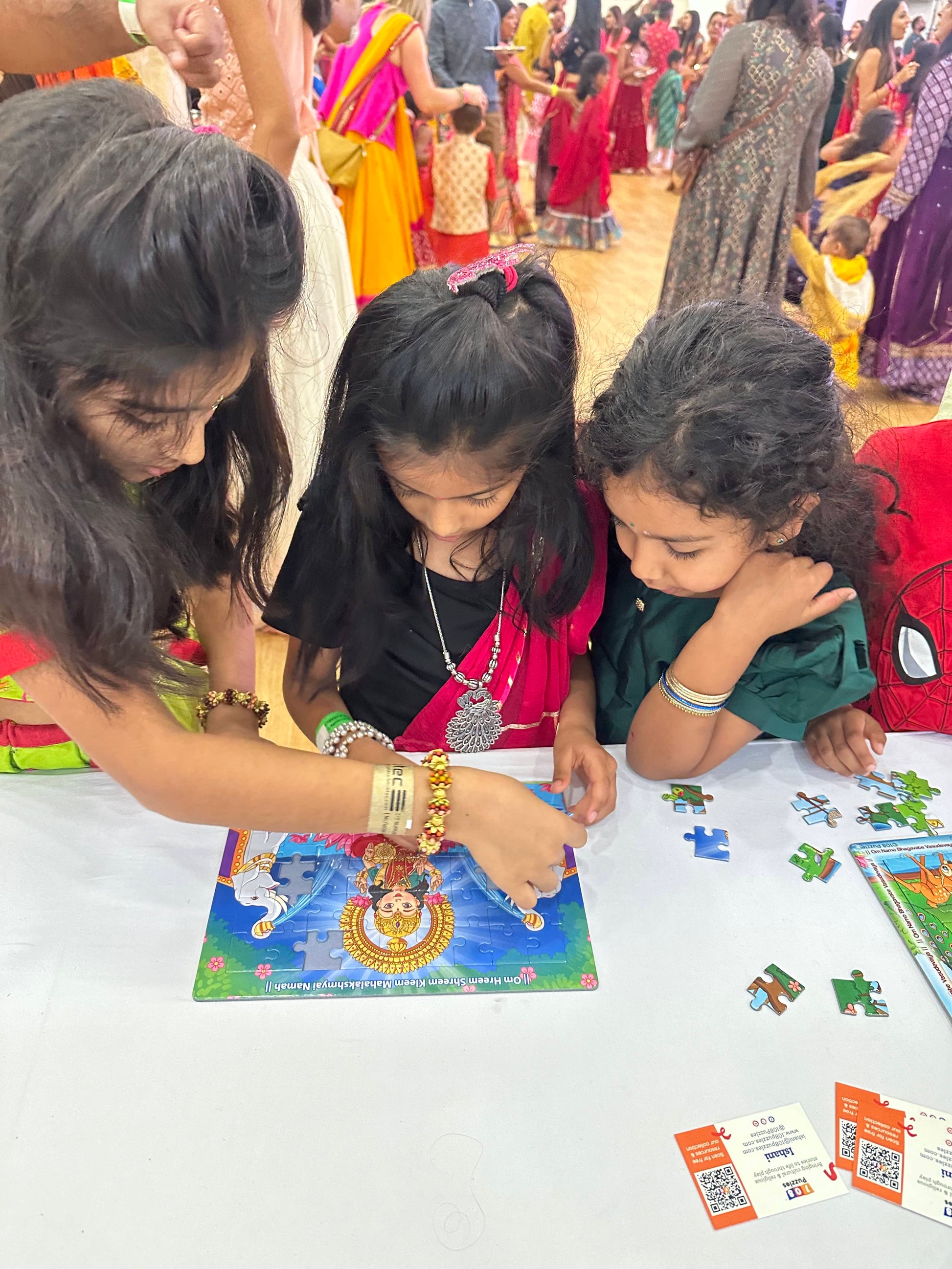 girls enjoying playing with the lakshmi jigsaw puzzle at navratri in london