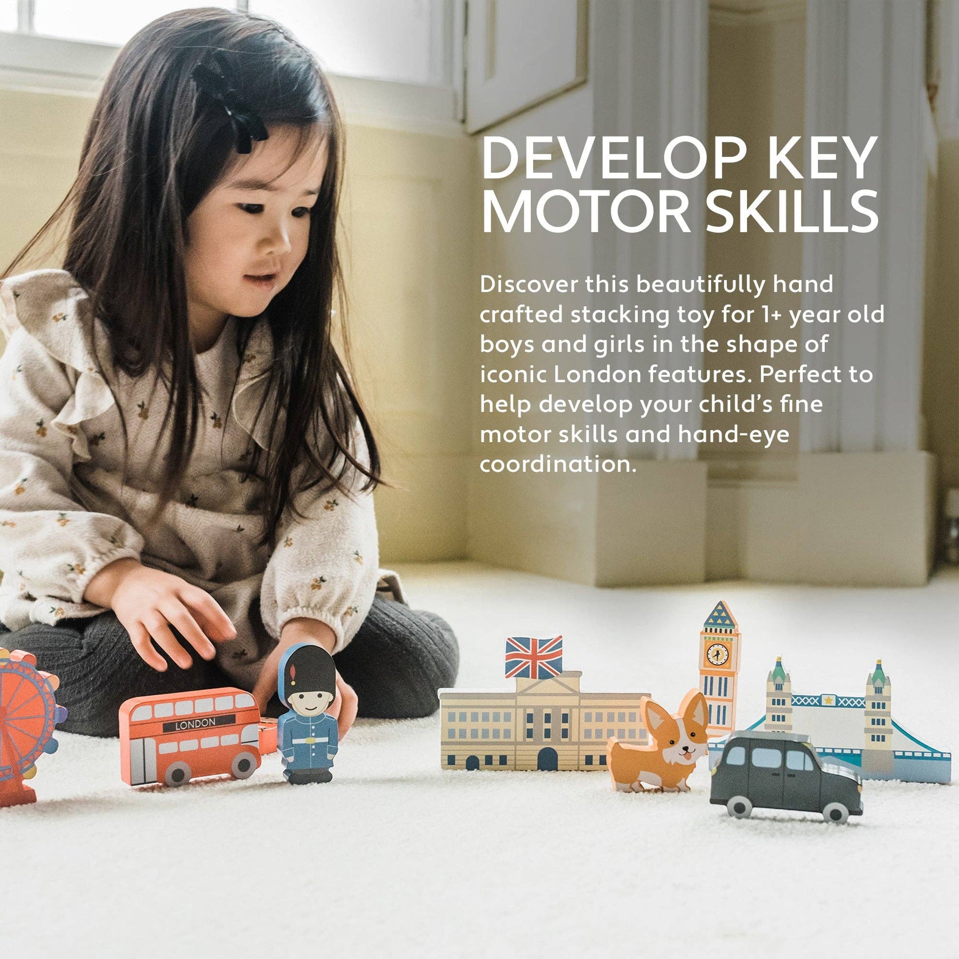 Child playing with toy London-themed set on a light-colored floor.