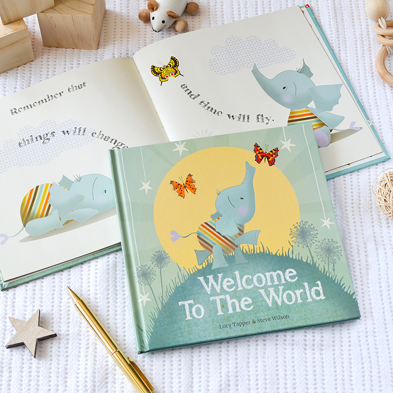 Children's book titled 'Welcome To The World' with illustrations of elephants and butterflies on a textured surface.