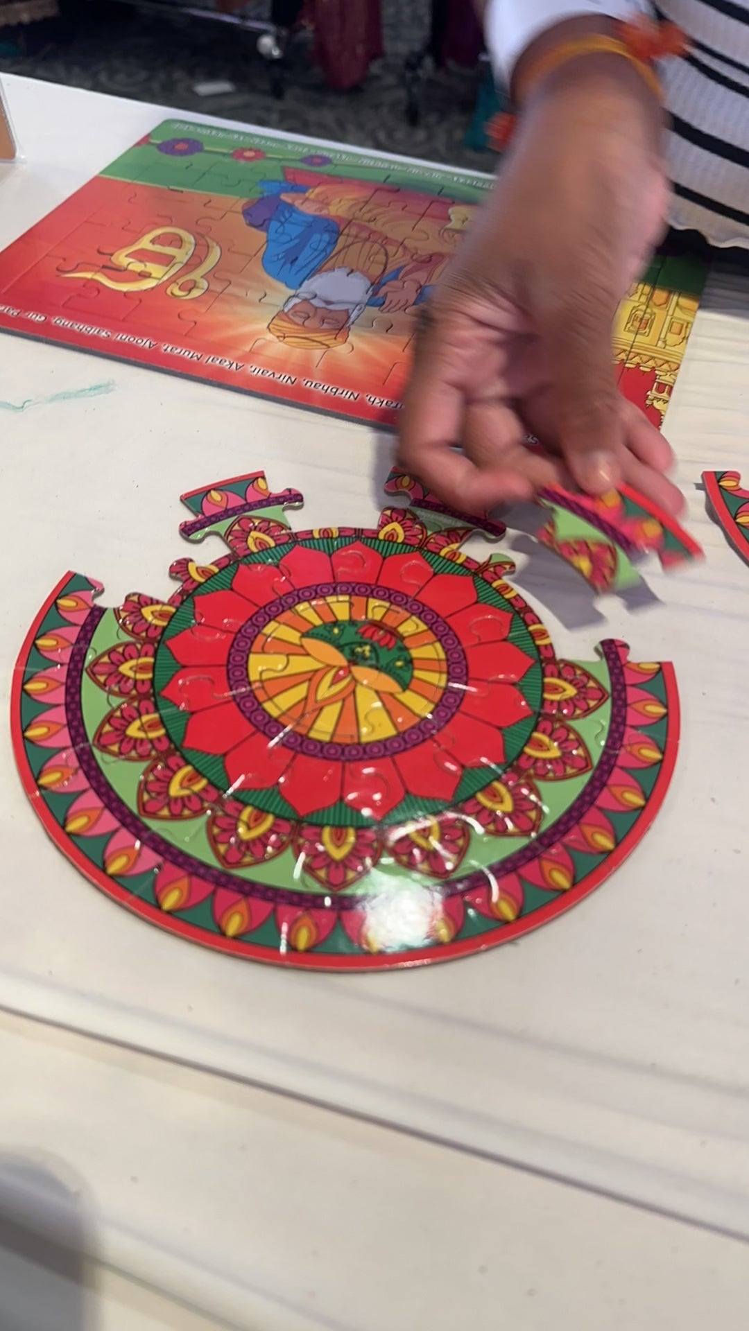 Girl piecing together rangoli puzzle at  Diwali event